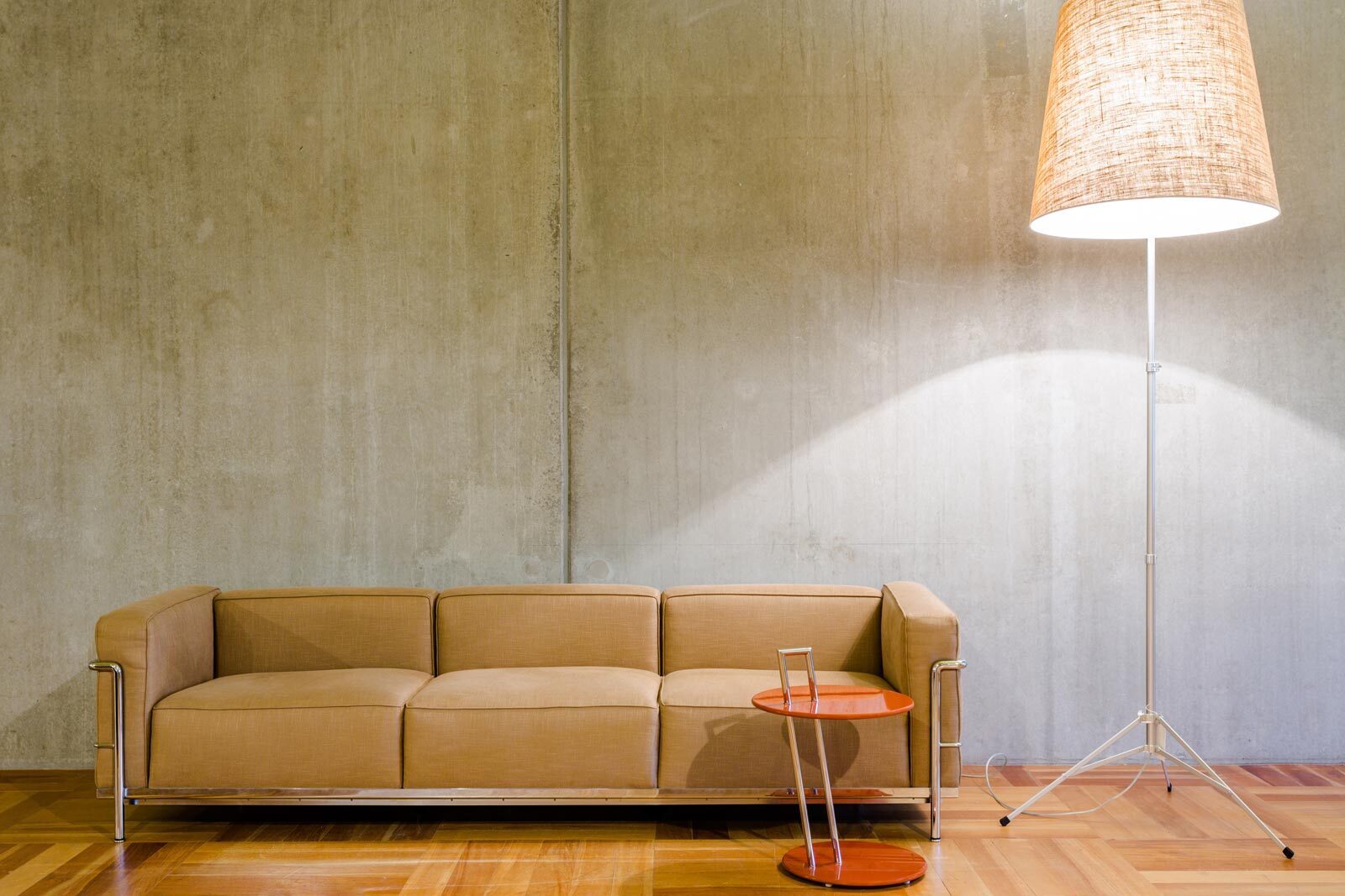 Betonnen wand met meubulair en lamp