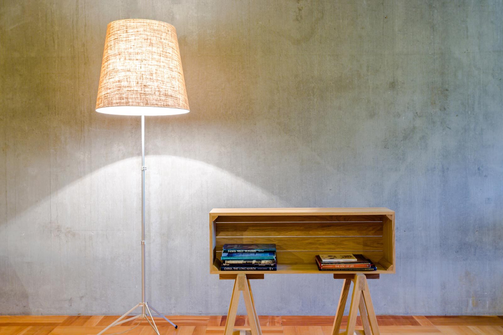 Betonnen wand met staande lamp en bijzettafel