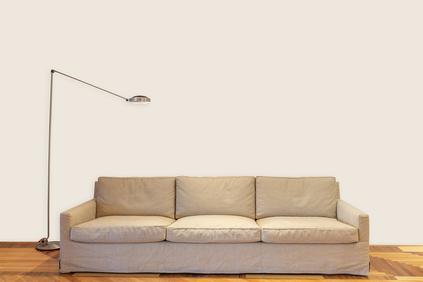 Witte wand met bruine bank en staande lamp M