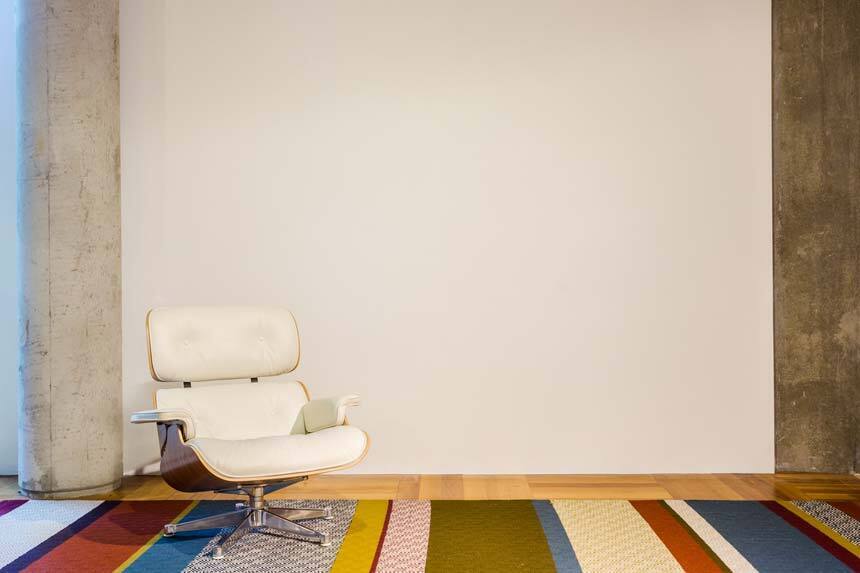 Witte wand met fauteuil en tapijt