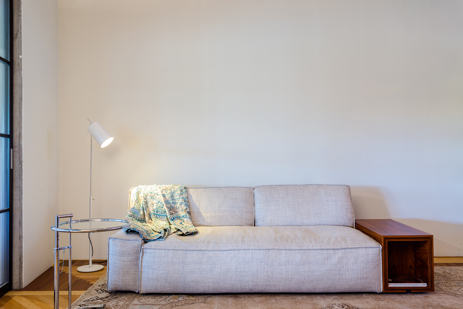 Witte wand met meubulair tapijt en lamp