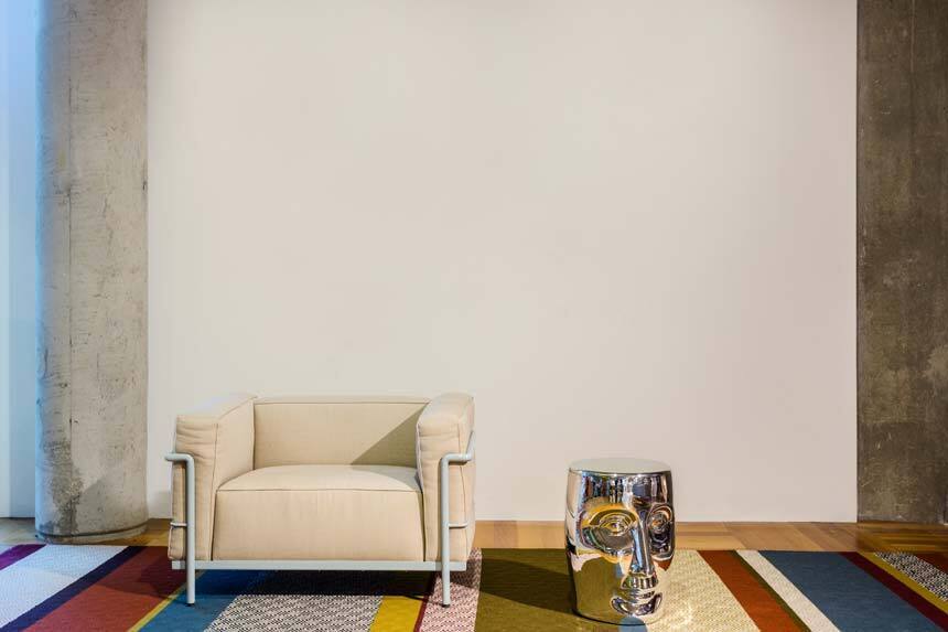 Witte wand met pilaar licht meubulair en tapijt